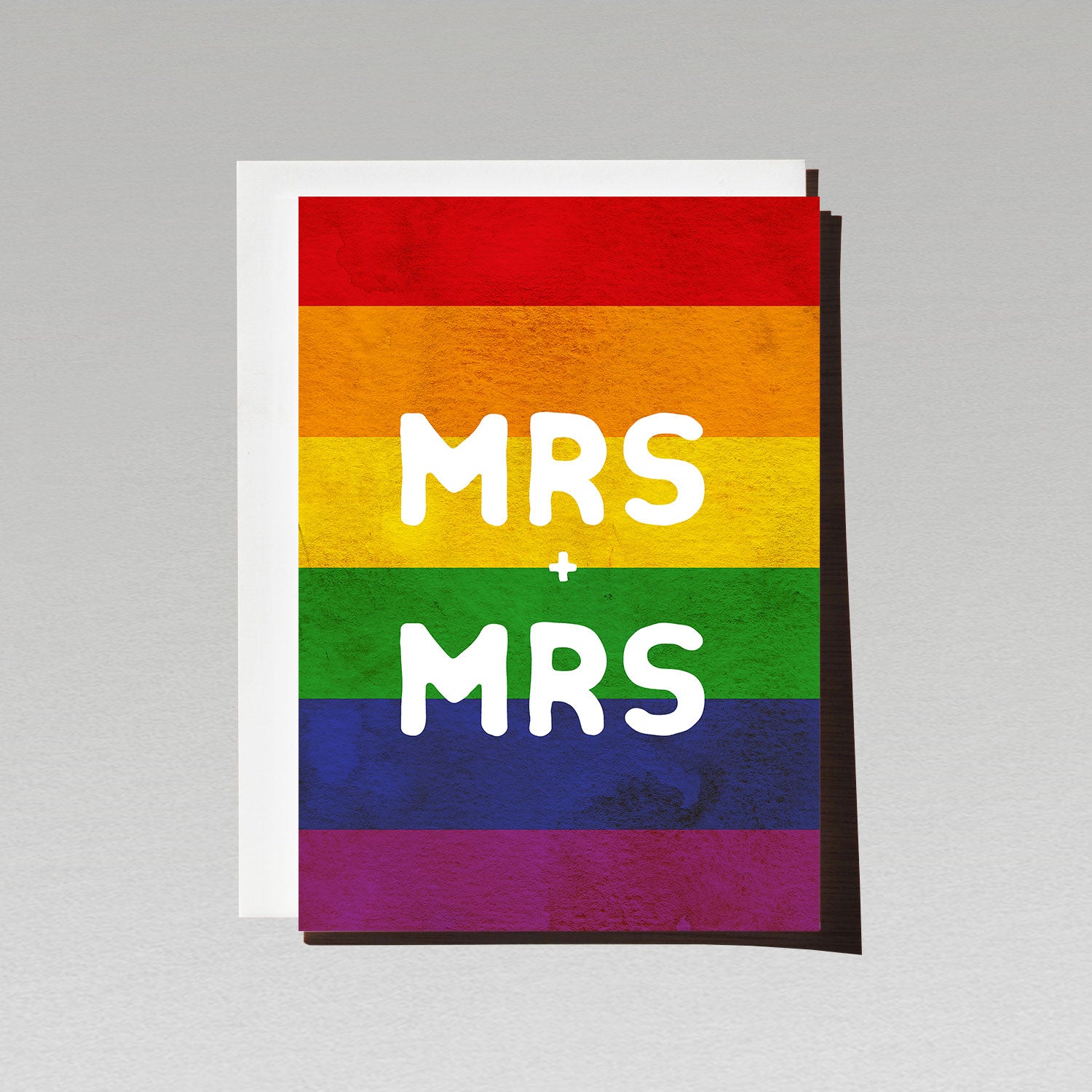 Greeting card with large white text Mrs + Mrs on LGBTQI rainbow flag background